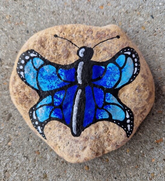 Blå sommerfugl tegnet på sten